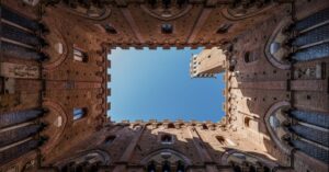 Stunning upward view of the Palazzo Pubblico courtyard in Siena, Italy.