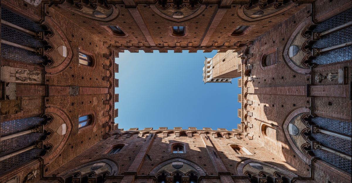 Stunning upward view of the Palazzo Pubblico courtyard in Siena, Italy.
